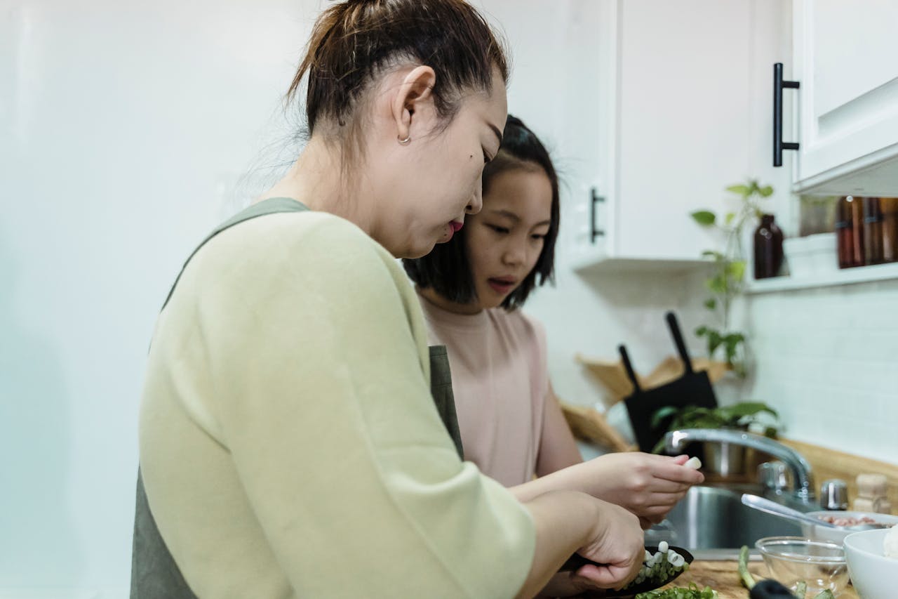Mastering the First Impression: Your intriguing post title goes here Mother and daughter enjoying quality time cooking together in a modern kitchen setting.
